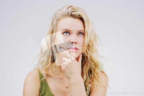 Image of Young woman, thinking and decision in studio with ideas, memory and focus by gray background. Girl, model and think with concentration, remember and confused for choice, planning or question on mind