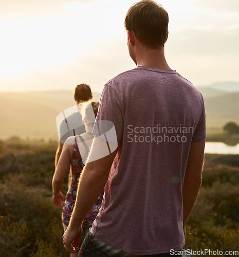 Image of Friends, people hiking and trekking in countryside with fitness at sunset, nature with travel together and freedom. Exercise, adventure with men and woman walk through meadow or field with back view