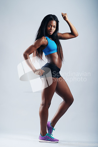 Image of Black woman, studio and flex with strong arm, confidence and body wellness by white background. Female bodybuilder, girl or model with power, healthy muscle or portrait for fitness, training or goal