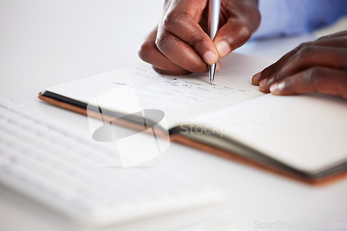 Image of Closeup, hands writing and notebook in office for brainstorming, ideas and focus on career goals. African man, book and pen for schedule, administration or agenda with planning, journal and notes