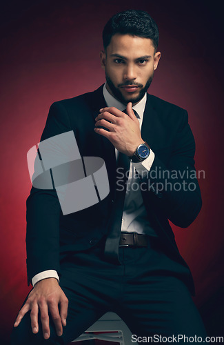 Image of Young man, suit and studio portrait with business fashion, dark and mysterious aesthetic by red background. Businessman, formal and professional clothes with entrepreneurship, career and backdrop