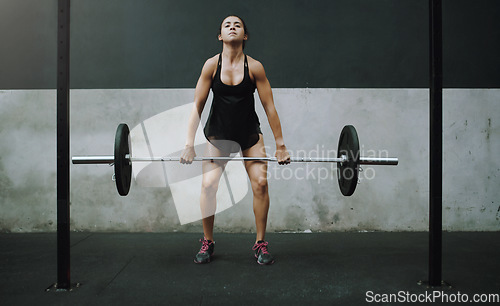 Image of Strong, weight lifting and woman with barbell in gym for training, exercise and intense workout. Fitness, deadlift and female body builder lift weights for challenge, wellness and muscle strength