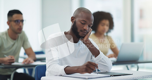 Image of Black man, student desk and bored in university class with learning for college test at table. Book, school study and African male person thinking, writing and lecture notes for studying in classroom