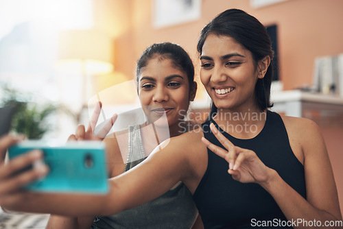 Image of Peace sign, exercise selfie and women together at home for social media memory, emoji or post. Indian sisters or female friends taking photo for influencer update, fitness motivation or happy results