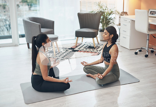 Image of Friends, meditate and women exercise together in a house for health, mindfulness or wellness. Indian people in a home for meditation workout, lotus pose and fitness with a partner for zen and peace