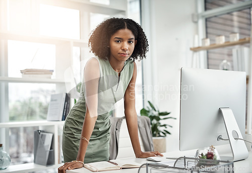 Image of Computer, portrait and serious business woman working by her desk or table in a corporate startup company. Internet, online and young professional female employee or planner in an agency office