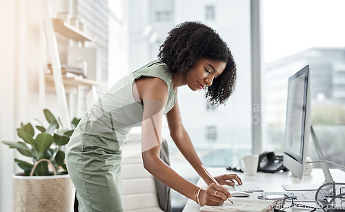 Image of Computer, schedule and business woman writing and standing by her desk or table in a corporate startup. Internet, online and professional female employee, assistant or planner planning in a notebook