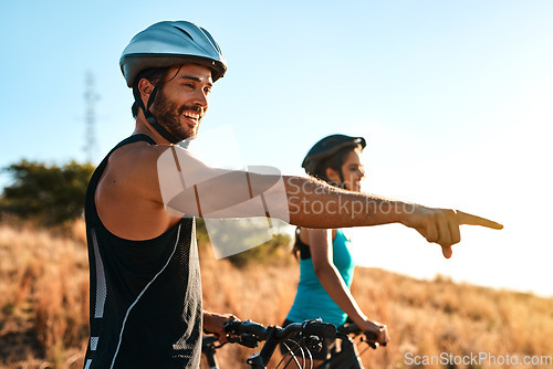 Image of Happy couple, pointing and cycling in the mountains for fitness and exercise together. Bike, wellness and young man with woman outdoor for adventure, sports or happiness of freedom on blue sky mockup