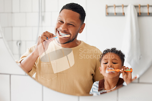 Image of Brushing teeth, father and child in a home bathroom for dental health and wellness with smile. Face of a man and african boy kid learning to clean mouth with a toothbrush and mirror for oral hygiene