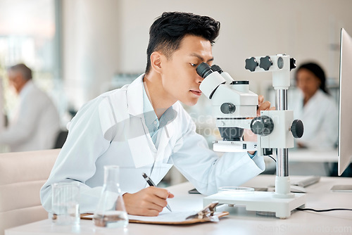 Image of Science, notebook and microscope with an asian man doctor working in a lab for research or innovation. Healthcare, medical and writing with a male scientist working in a laboratory for analysis