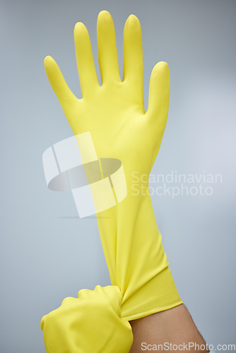 Image of Hands, cleaning and rubber gloves for safety or hygiene while indoor for chores or housework as a maid. Bacteria, service and latex with a cleaner or janitor getting ready for housekeeping duties