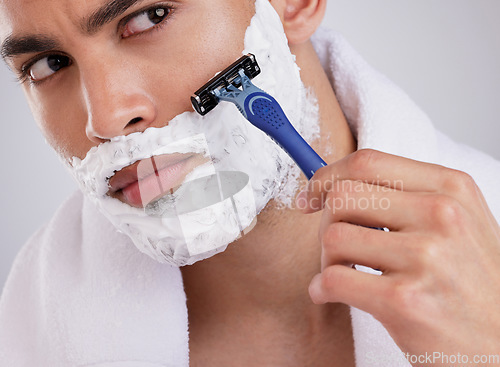 Image of Hair removal, shaving and foam with man in studio for beauty, grooming or skincare. Cosmetics, self care and shower with face of male model and razor blade on gray background for cleaning and product