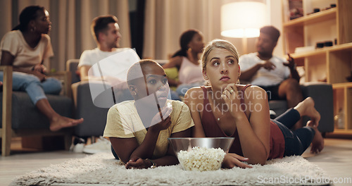 Image of Friends, popcorn and movie at home at night for entertainment and relaxing for enjoyment. Friend, together and watching tv in the lounge with a snack in the evening to relax on the weekend for fun.