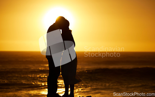 Image of Couple, siilhouette and kiss at sunset on a beach for vacation, holiday or mockup outdoor. Romantic man and woman in nature with creative sky, care and ocean for love, shadow art and travel freedom