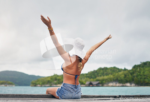 Image of Island, ocean and happy woman relax on deck for holiday, summer vacation and weekend getaway in Maldives. Luxury resort, tropical beach and female person with arms up for tourism, sea and adventure