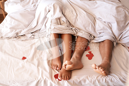 Image of Bed, legs and couple with Valentines Day heart, romance or emoji icon for home love, intimacy and honeymoon affection. Marriage bond, relax sleep and top view feet of people sleeping in hotel bedroom