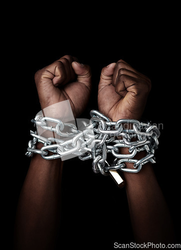 Image of Chain, hands and prisoner of slavery isolated in studio on a black background. Chained, slave and hand of person in bondage, hostage or criminal in jail after arrest for crime, law and punishment.