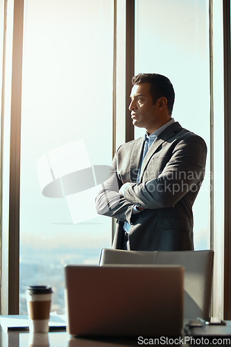 Image of Thinking, office window and serious man with business idea, plan or vision in high rise building. Professional, entrepreneur and male CEO with arms crossed for inspiration, dream and corporate goals