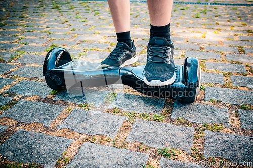 Image of Teenager riding a hoverboard at schoolyard - self-balancing scooter, levitating board used for personal transportation