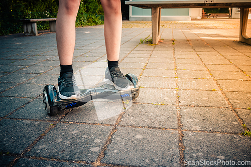 Image of Teenager riding a hoverboard at schoolyard - self-balancing scooter, levitating board used for personal transportation