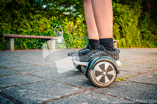 Image of Teenager riding a hoverboard at schoolyard - self-balancing scooter, levitating board used for personal transportation