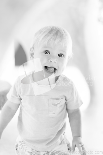 Image of Black and white portrait of cute little infant baby boy child playing on outdoor playground. Toddler plays on school or kindergarten yard.