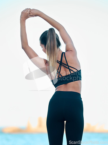 Image of Back, exercise and woman stretching, beach and workout goal for wellness, meditation and health. Female person, girl and athlete stretch, seaside or break with fitness, training and yoga with peace