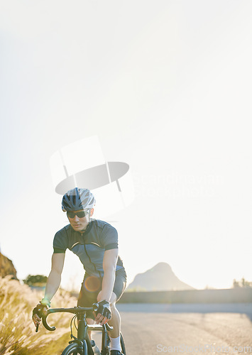 Image of Training, bike and cycling with a sports man on a road through the mountain for cardio or endurance. Exercise, workout or fitness with a male cyclist riding his bicycle on an asphalt street in nature