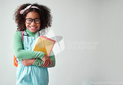 Image of School, portrait of child student with books for knowledge, education and studying in a studio. Happy, smile and young smart girl kid with glasses for reading by a white background with mockup space.