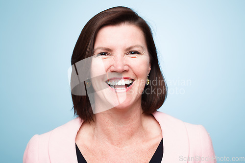 Image of Happy, portrait of mature woman smile and against a blue background for health wellness. Happiness, mock up space and excited or cheerful female person smiling with pose against a studio backdrop