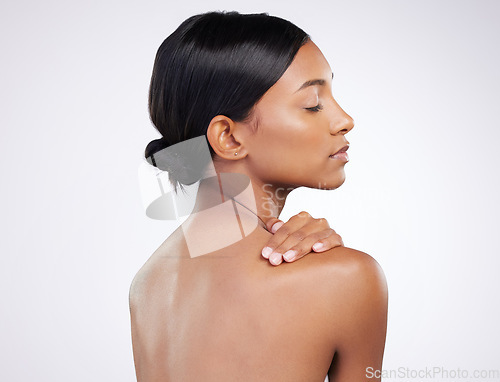 Image of Woman, skincare and relaxed with back in studio for wellness, healthy glow and self care by white background. Indian model girl, skin health and soft touch with cosmetics, thinking and aesthetic