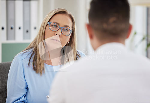 Image of Mature woman, psychiatrist and patient talking during consultation in the clinic or psychologist listen to a man at the office. Mental health, female therapist and conversation or guy for healing