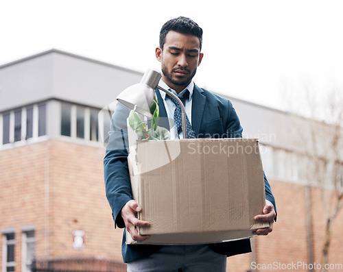 Image of Economy, dismissal and a fired business man carrying a box while walking outdoor in the city. Financial depression, unemployment and jobless with a young male employee looking sad in an urban town