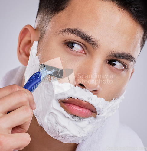 Image of Beard, shaving and foam with man and razor in studio for hair removal, grooming and skincare. Cosmetics, self care and morning with face of model on gray background for cleaning and shaver product