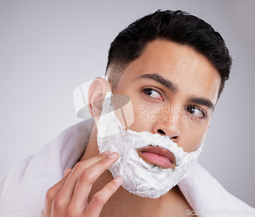 Image of Shaving, cream and foam with face of man in studio for hair removal, beauty and skincare. Cosmetics, self care and morning with model and beard grooming on gray background for cleaning and product