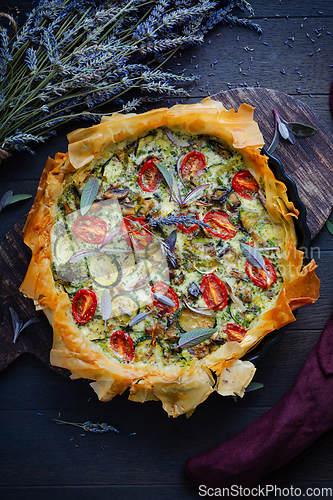 Image of Delicious vegetarian summer quiche with zucchini, tomato, mushrooms, sage and lavender with phyllo pastry