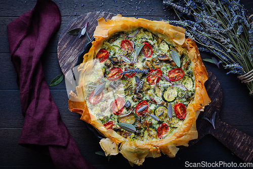 Image of Delicious vegetarian summer quiche with zucchini, tomato, mushrooms, sage and lavender with phyllo pastry