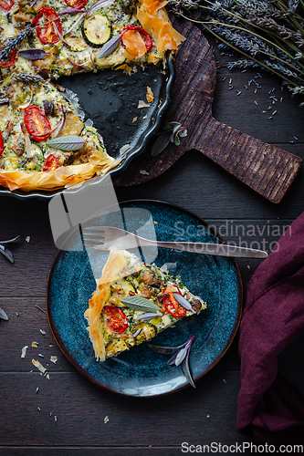 Image of Delicious vegetarian summer quiche with zucchini, tomato, mushrooms, sage and lavender with phyllo pastry