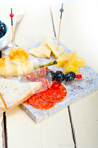 Image of mix cold cut on a stone with fresh pears