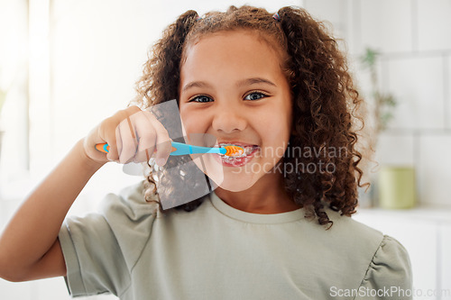 Image of Toothbrush, brushing teeth and portrait of a child in a home bathroom for dental health and wellness with smile. Face of Latino girl kid learning to clean her mouth for morning routine and oral care