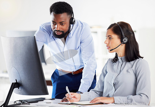 Image of Collaboration, mentor helping with colleague and headset with computer at her desk of modern office. Teamwork or support, partnership or communication and black man with intern at her workspace