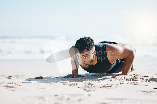 Image of Man, beach and pushup on sand for exercise, fitness or workout for performance in summer sunshine. Young guy, bodybuilder and training for health, wellness and strong body with self care on ground