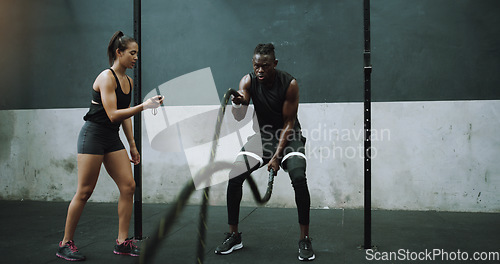 Image of Battle rope, exercise and man with personal trainer and stopwatch at gym for training goals on wall background. Heavy, full body and male with coach at sports center for power, workout or resilience