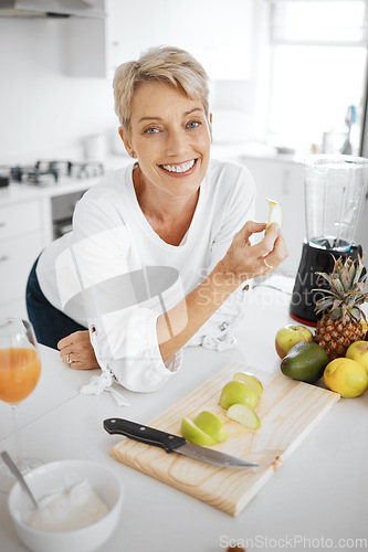 Image of Portrait, fruit salad and apple with an old woman in the kitchen of her home for health, diet or nutrition. Smile, food and cooking with a happy mature female pensioner eating healthy in the house