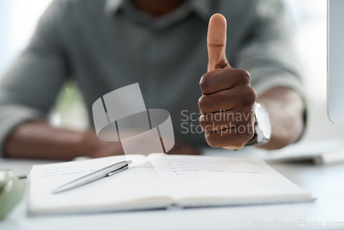 Image of Man, hands and notebook with thumbs up for winning, achievement or good job on office desk. Hand of male person with book in planning showing thumb emoji, yes sign or like for approval at workplace