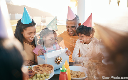 Image of Birthday, party and family outdoors for celebration, bonding and present, happy and excited. Parents, children and gift for girl child at special event, smile and celebrating with food at restaurant