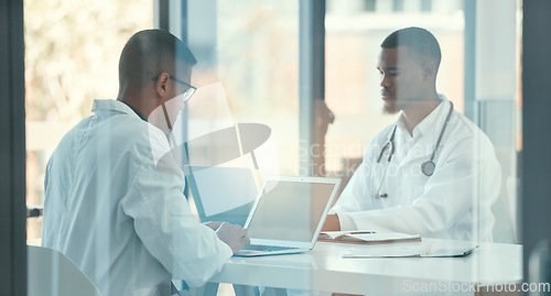 Image of Meeting, laptop and team of doctors for healthcare coworking, discussion and online management. Working, typing and medical people on computer, telehealth and research behind glass window in office