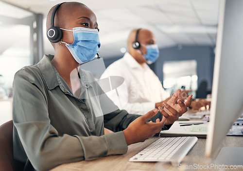 Image of Call center, face mask and a woman at computer with headset for safety compliance or health. African female agent talk at pc for customer service, help desk or crm with covid or bacteria protection