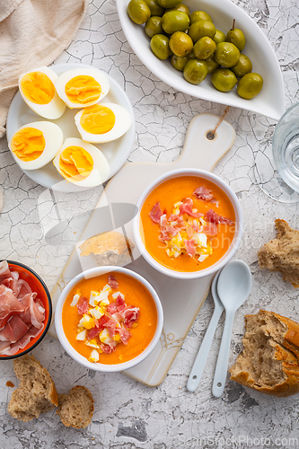 Image of Salmorejo - raw tomato soup with ingredients on a kitchen table,  spanish cuisine for hot summer