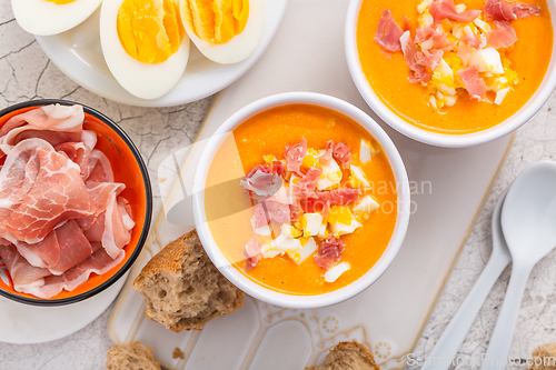 Image of Salmorejo - raw tomato soup with ingredients on a kitchen table,  spanish cuisine for hot summer